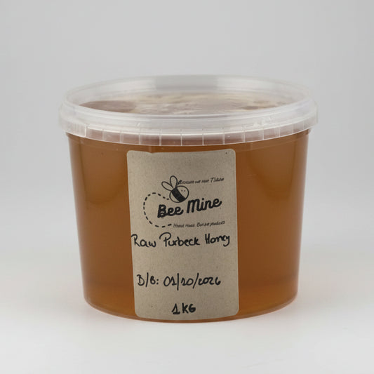 Container of raw honey with a label on a white background