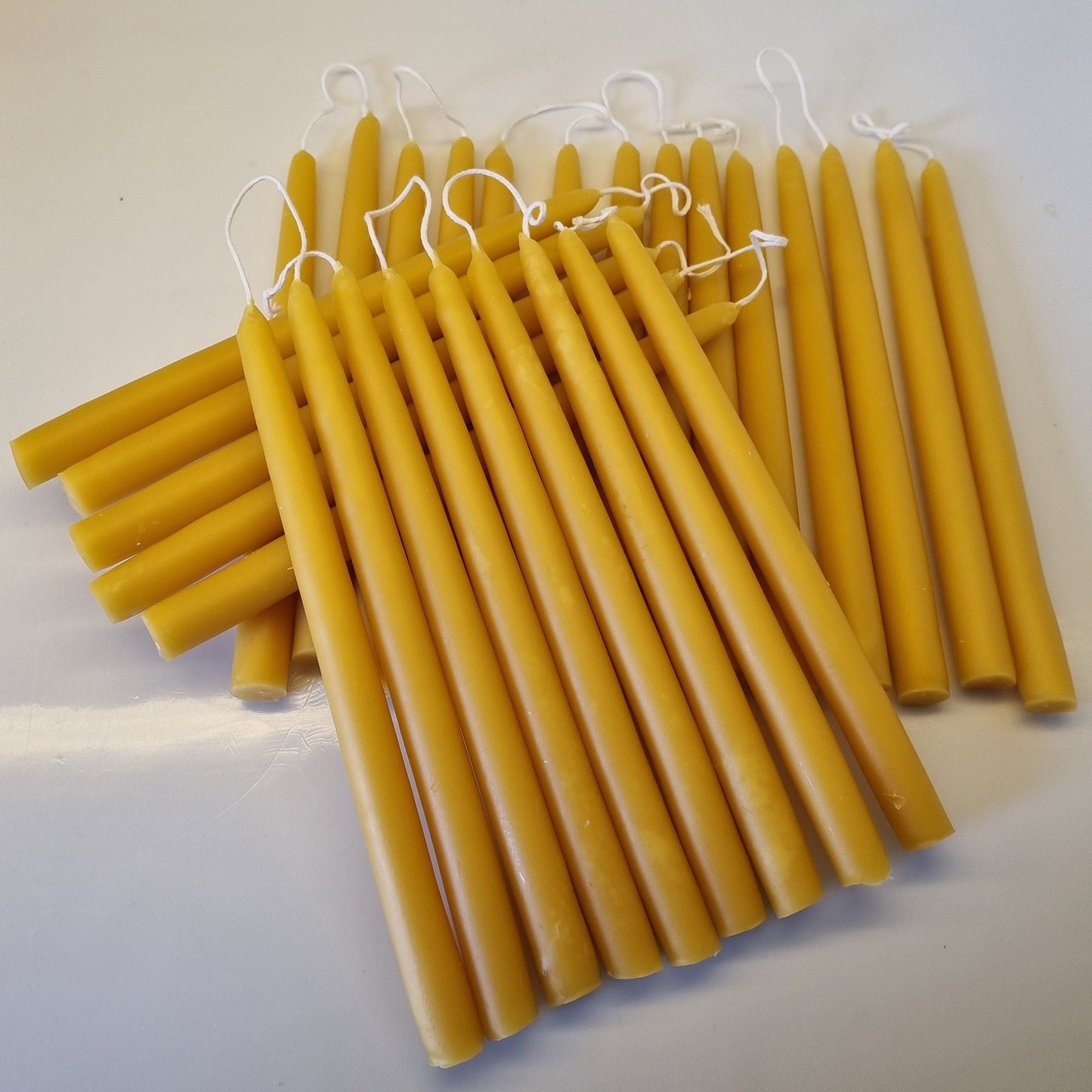 Yellow candles on a white surface